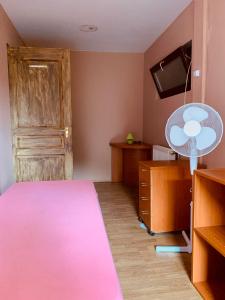 布达佩斯威廉姆斯村保龄球及乡村俱乐部酒店的卧室配有粉红色的床和风扇。