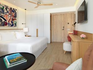 马拉加H10 Croma Málaga的酒店客房配有白色的床和桌子