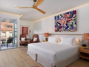 马拉加H10 Croma Málaga的一间带白色大床的卧室和一间客厅