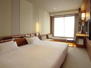 长崎Candeo Hotels Nagasaki Shinchi Chinatown的窗户客房内的一张大白色床