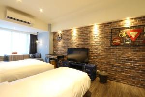 台北沐House的酒店客房带两张床和砖墙