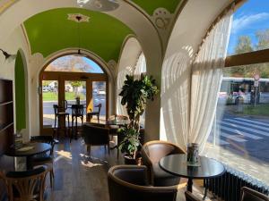 斯皮什新村维努萨旅馆的餐厅设有桌椅和窗户。