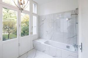 汉堡Sleephotels Alsterroom的白色的浴室设有浴缸和窗户。
