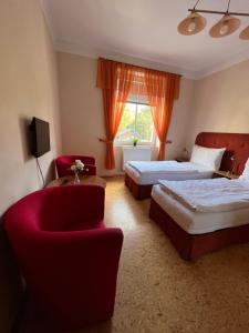拉贝河畔乌斯季Penzion Greenstar的酒店客房,设有两张床和一张红色椅子