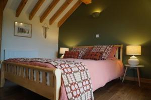 纽伯勒Tyddyn Plwm Isa的一间卧室设有一张床和绿色的墙壁