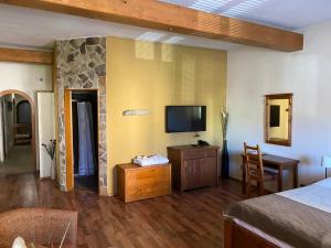 斯皮什新村维努萨旅馆的一间设有床铺和墙上电视的房间