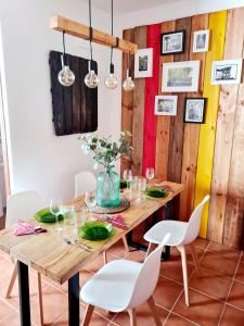 Los RomerosLa Casa Junto al Sendero del Río & Chimenea y leña incluida的一间带木桌和白色椅子的用餐室