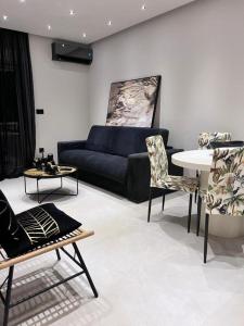 拉格尼西Lagonisi Luxury Apartment by the sea的客厅配有沙发和桌椅