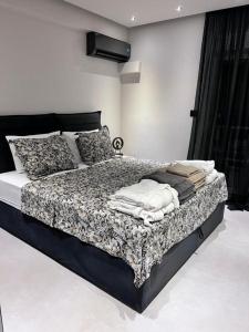 拉格尼西Lagonisi Luxury Apartment by the sea的卧室配有带枕头的黑白床。