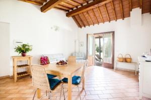 奥尔贝泰洛Agriturismo Fontetrilla的厨房以及带木桌和椅子的用餐室。