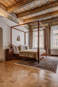布拉格Hotel Nerudova 211的一间卧室设有天蓬床和格子天花板
