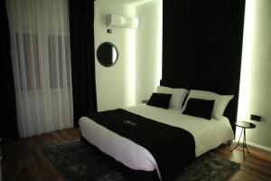 地拉那Dark Boutique Hotel的一间卧室配有一张大床,提供黑白枕头