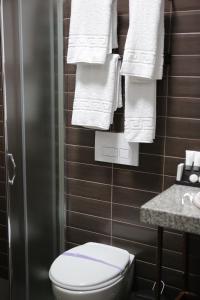 地拉那Dark Boutique Hotel的一间带卫生间和白色毛巾的浴室