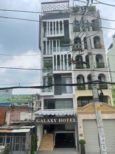 胡志明市Galaxy Hotel 3的一座高大的白色建筑,设有画廊酒店