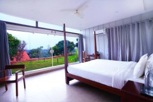 RāmanagaramRavishing Retreat Resort的一间卧室设有一张床和一个大窗户