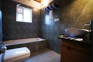 RāmanagaramRavishing Retreat Resort的带浴缸、盥洗盆和卫生间的浴室