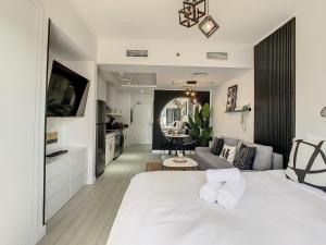 迪拜Luxury Modern Studio in JLT with Amazing View & Rooftop Pool - sleeps 3的一间带白色床的卧室和一间客厅