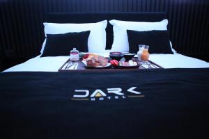 地拉那Dark Boutique Hotel的床上的食品和饮料托盘