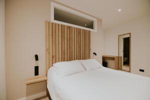 圣比森特德拉松谢拉Casa La Picuda的卧室配有白色的床和窗户。
