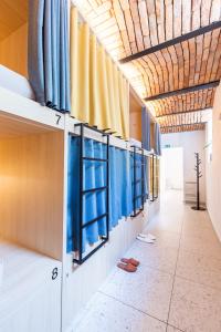 卢布尔雅那Boutique Hostel Angel的走廊上设有蓝色和黄色的窗帘和鞋子