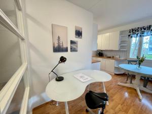 波尔沃Porvoon Kartanonpuisto的白色的客房配有桌子和书桌
