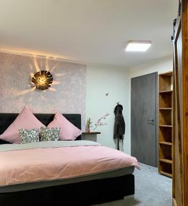 KonradsreuthBrauhaisla的一间卧室配有粉红色的床和带镜子的墙壁