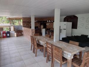 瓜拉派瑞Pousada Moinho D'água的一间厨房和一间带木桌及椅子的客厅
