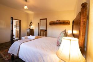 格拉夫-里内特Wild Olive Cottage的卧室配有一张带灯的白色大床