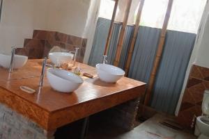 卡诺阿斯德蓬萨尔Fundo Matufa Mancora的浴室设有木柜台上的2个碗