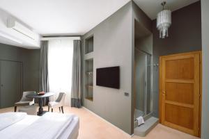 卢卡Palazzo Froussard B&B and Living的一间卧室配有一张床、一张桌子和一台电视