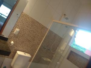 乌巴图巴Toca do Guaiamum I的一间带卫生间和玻璃淋浴间的浴室