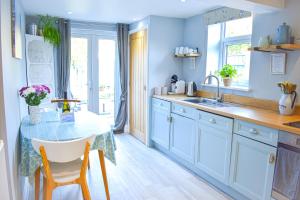 PakefieldAvocet - Suffolk Coastal Escapes的蓝色的厨房,配有桌子和水槽