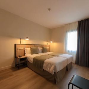 安道尔城梅非尼酒店的一间卧室设有一张大床和一个窗户。