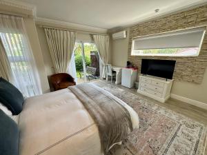 开普敦Constantiaberg Eco-Villa的一间卧室配有一张床和一台平面电视