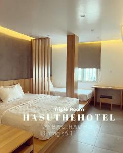 迪石Hasu The Hotel的配有一张床和一张书桌的酒店客房