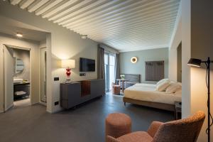 巴里VIS Urban Suites&Spa的卧室配有床、电视和椅子
