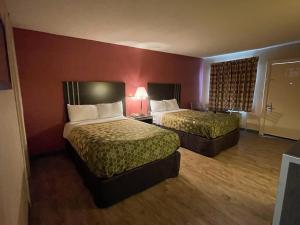 东哈特福德Economy Inn的酒店客房设有两张床和红色的墙壁。
