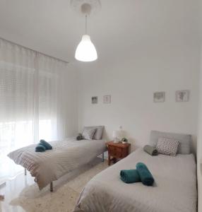 埃希哈Écija Home的一间卧室配有两张带绿色枕头的床。