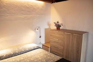 丰卡连特德拉帕尔马El Sueño: un lugar especial para sus vacaciones的一间卧室配有一张床和一个装有植物的梳妆台