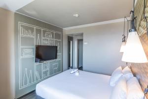 加亚新城波尔图盖亚诺宜必思酒店的一间卧室设有两张床,墙上配有电视。