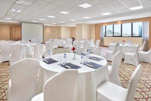 麦加玛卡利姆阿贝特酒店的一间会议室,配有白色的桌子和白色的椅子
