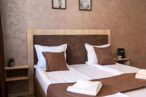 韦林格勒Luxor Apartment的一间卧室配有两张床,提供白色的床单和棕色的枕头