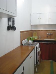 皮里亚波利斯Artemisa的厨房配有白色橱柜和木制台面