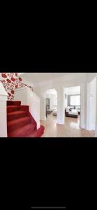 卢顿Beautiful mansion in private gated Rd Hot tub FREE SAUNA的一间客厅,客厅里设有红色地毯楼梯