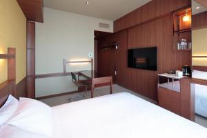 宇都宫Candeo Hotel Utsunomiya的配有一张床和一张书桌的酒店客房