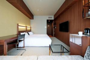宇都宫Candeo Hotel Utsunomiya的配有一张床和一张书桌的酒店客房
