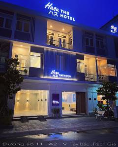 迪石Hasu The Hotel的一座建筑,上面有标志,在晚上读到吻Kx酒店