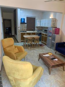 巴格达Dreams Apartments شقق الاحلام的客厅配有沙发椅和桌子