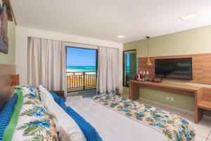 嘎林海斯港Vivá Porto de Galinhas Resort的一间带一张床和电视的卧室,享有海景