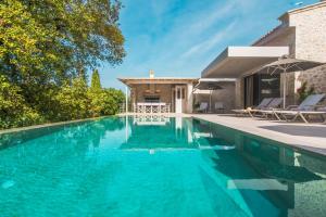 康托卡利My Mediterranean Corfu Luxury Villa with Private Swimming Pool的一座房子前面的蓝色海水游泳池